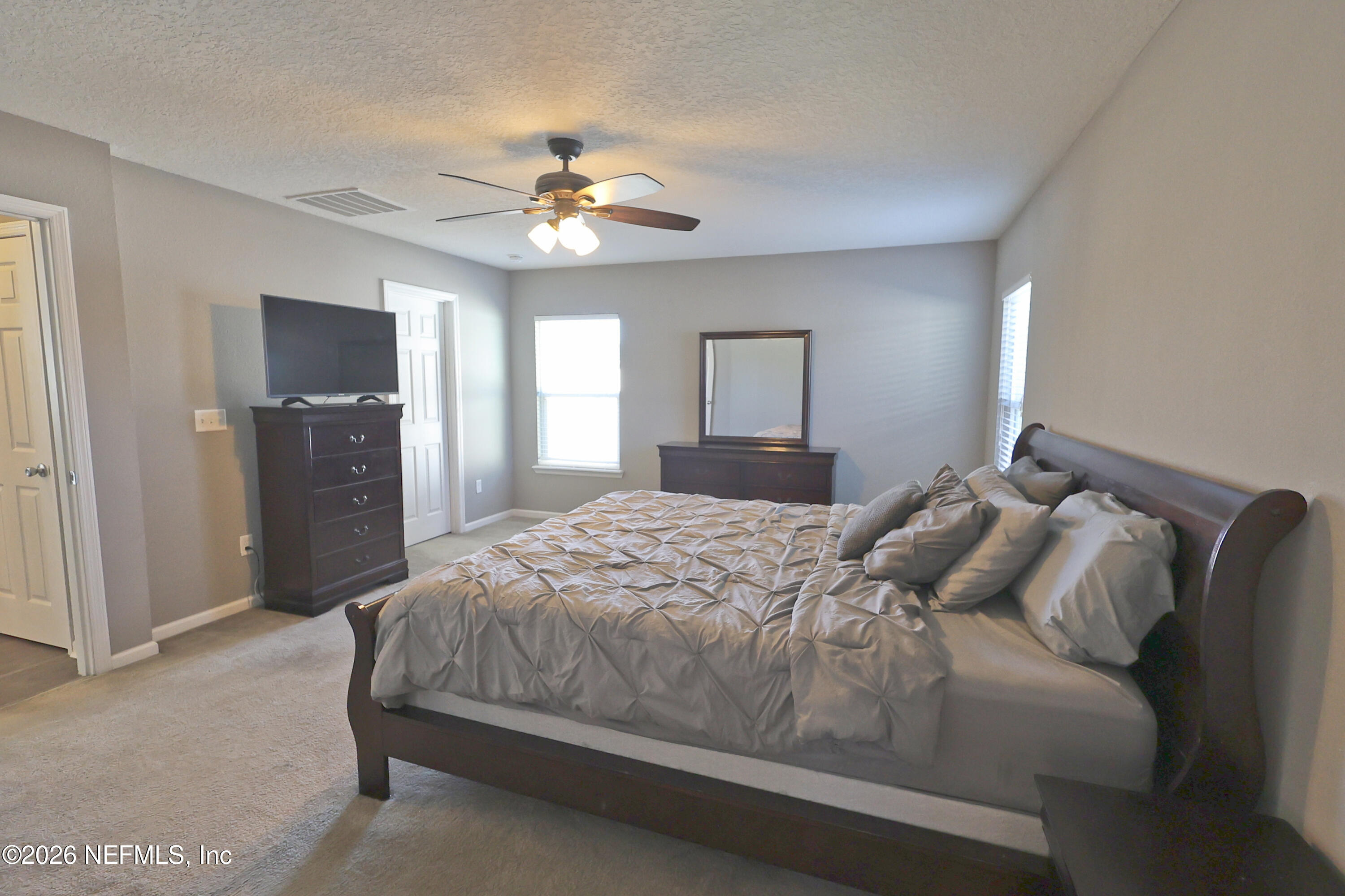 97569 Albatross Drive Yulee, FL 32097 - Photo 20 of 41 a bedroom with a large bed and a chandelier