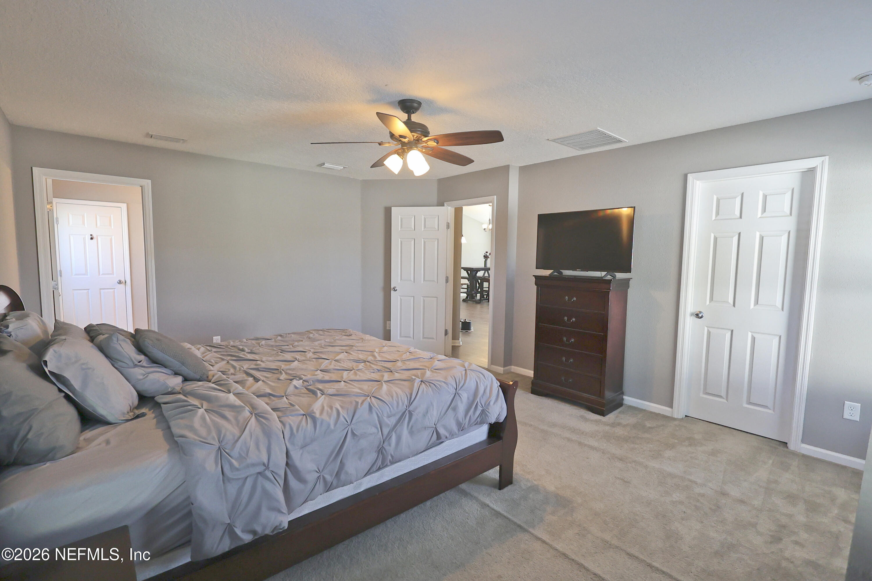 97569 Albatross Drive Yulee, FL 32097 - Photo 21 of 41 a bedroom with a bed ceiling fan and a wooden floor