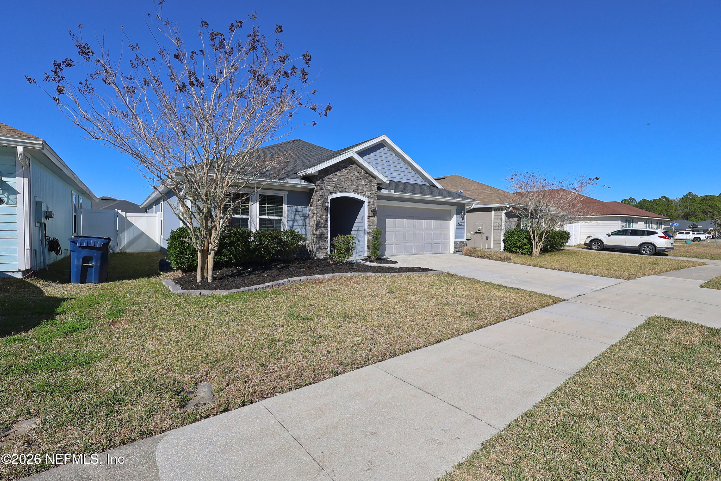97569 Albatross Drive Yulee, FL 32097 - Photo 4 of 41 a front view of a house with a yard and garage