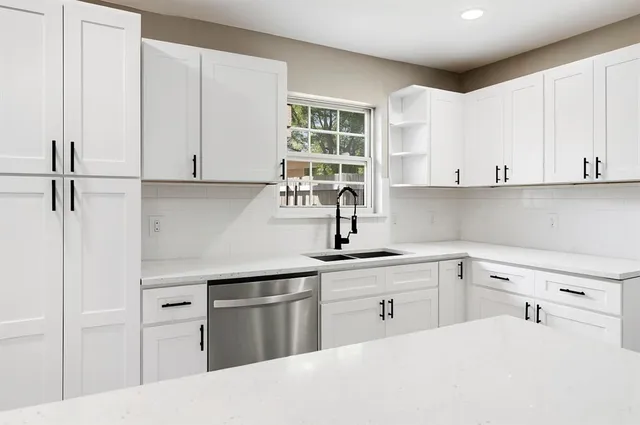 a kitchen with white cabinets and white appliances