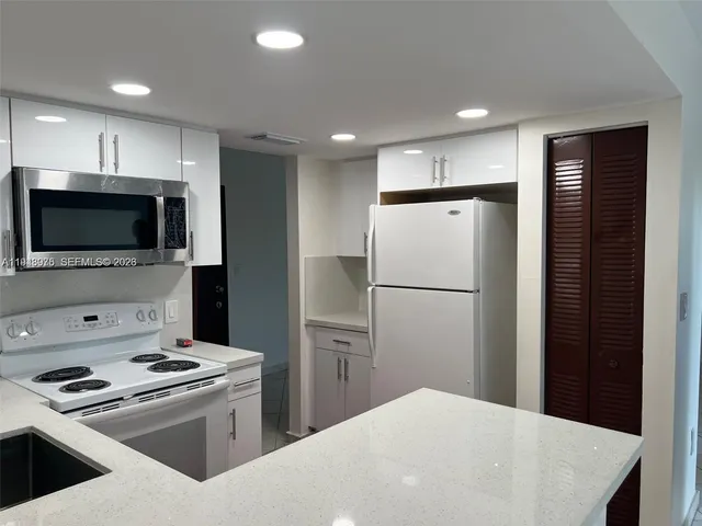 a kitchen with stainless steel appliances a refrigerator stove and microwave