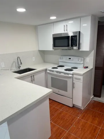 a kitchen with stainless steel appliances a sink stove and microwave