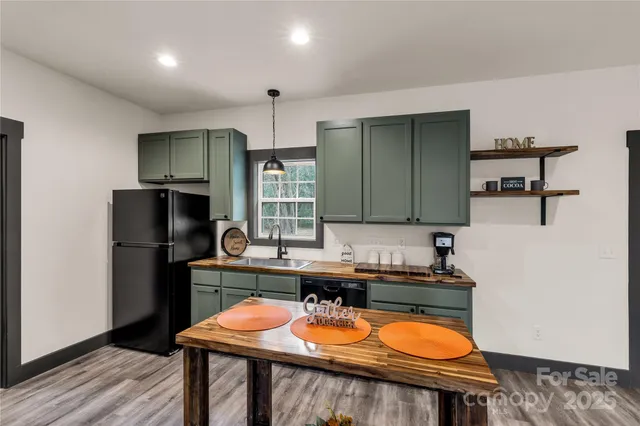 a kitchen with stainless steel appliances granite countertop a kitchen island a table and chairs in it