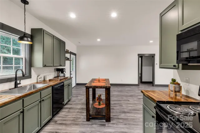 a kitchen with stainless steel appliances granite countertop a sink a stove and a wooden floors