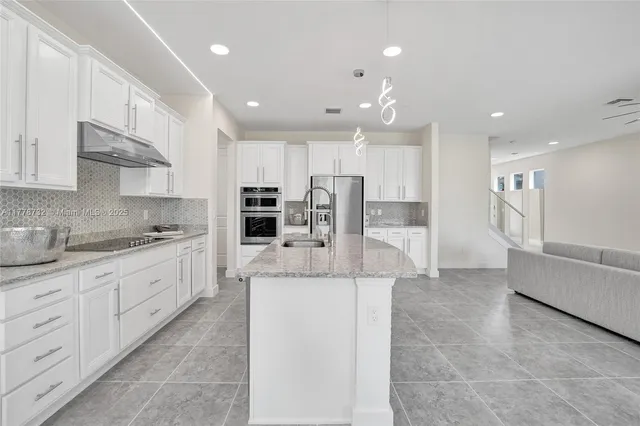 a spacious bathroom with a granite countertop sink a toilet and a mirror