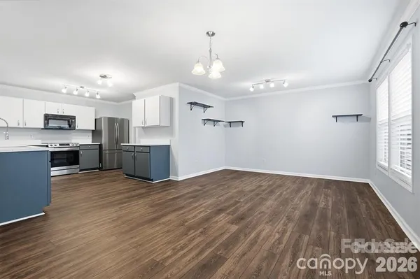 a kitchen with granite countertop a refrigerator stove and sink