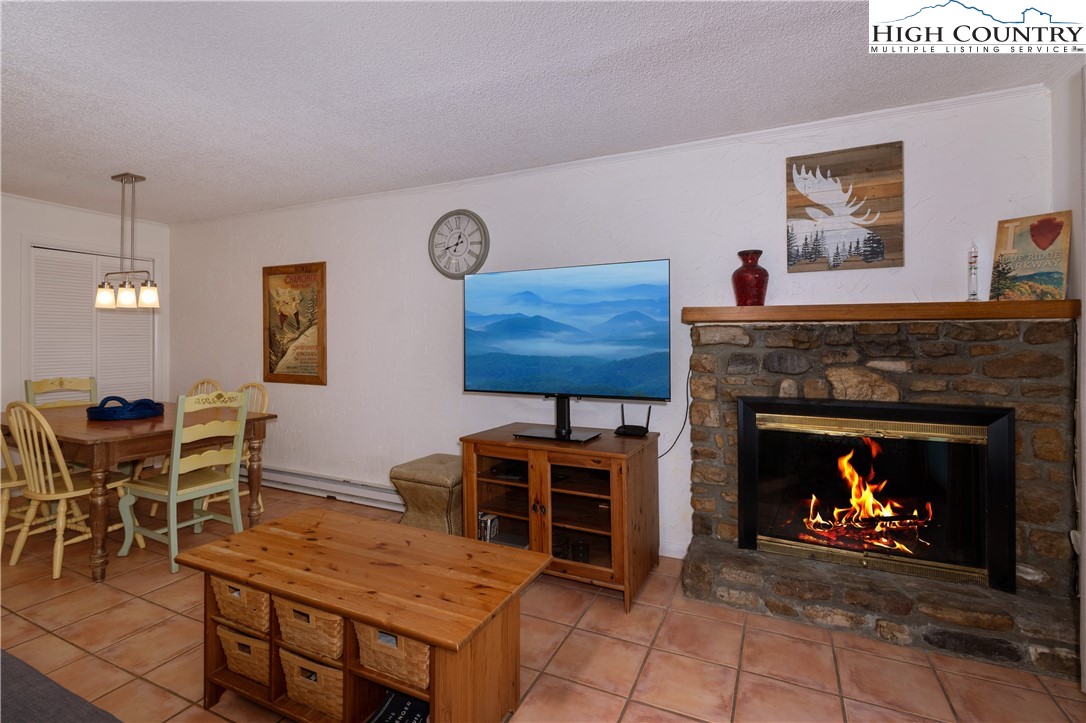103 Mid Holiday Lane, Unit 115D Beech Mountain, NC 28604 - Photo 4 of 25 a living room with furniture a fireplace and kitchen view