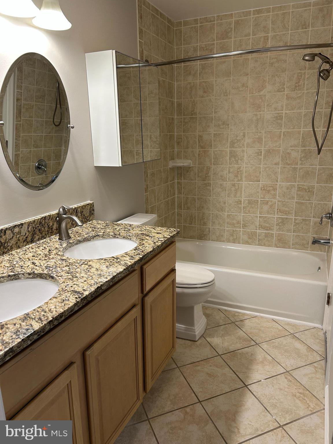 5761 H Rexford Court Springfield, VA 22152 - Photo 17 of 18 a bathroom with a granite countertop bathtub sink vanity mirror and toilet