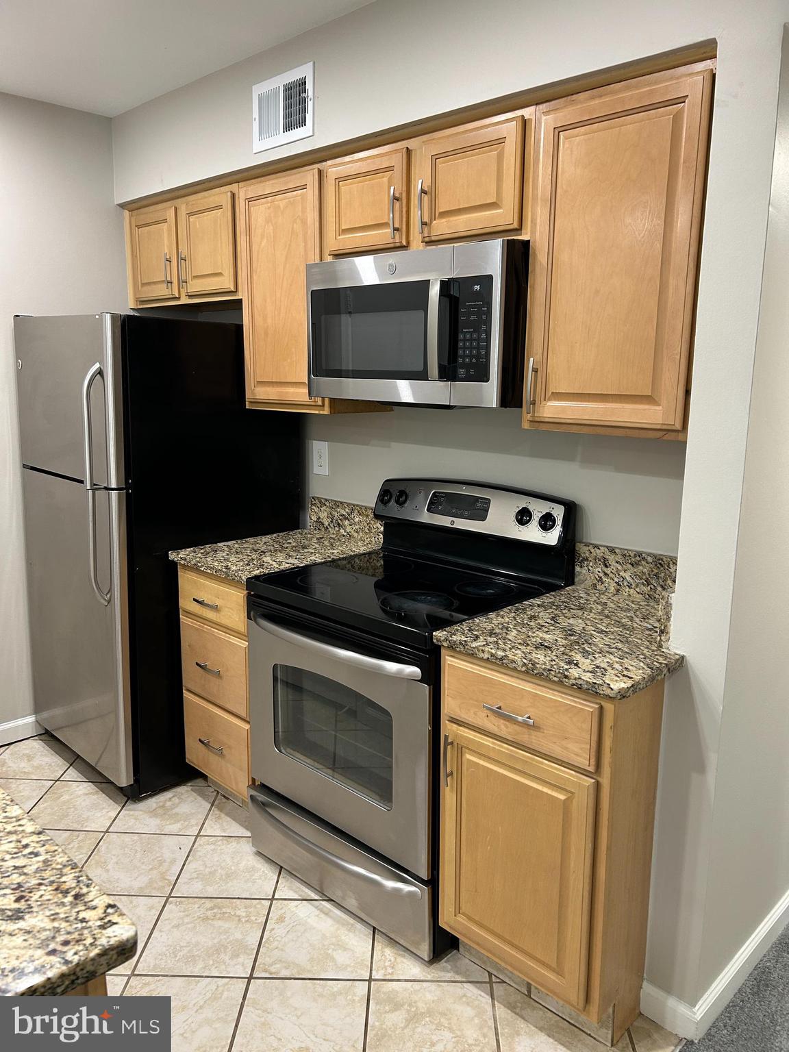 5761 H Rexford Court Springfield, VA 22152 - Photo 7 of 18 a kitchen with stainless steel appliances granite countertop a stove microwave and refrigerator