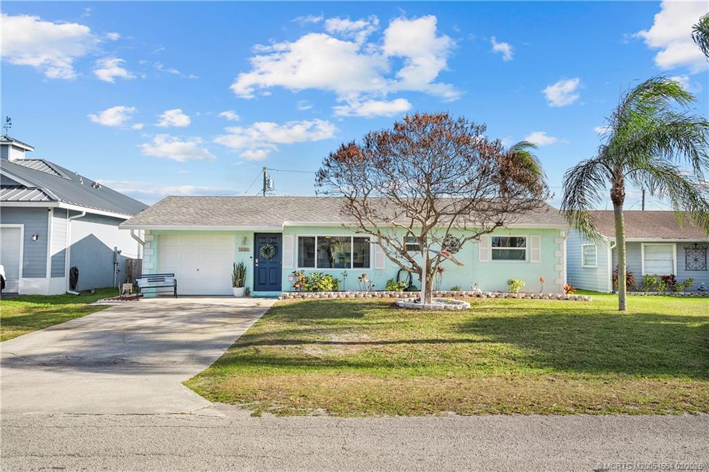 2602 Southeast Jackson Street Stuart, FL 34997 - Photo 5 of 53 a front view of a house with a garden and trees