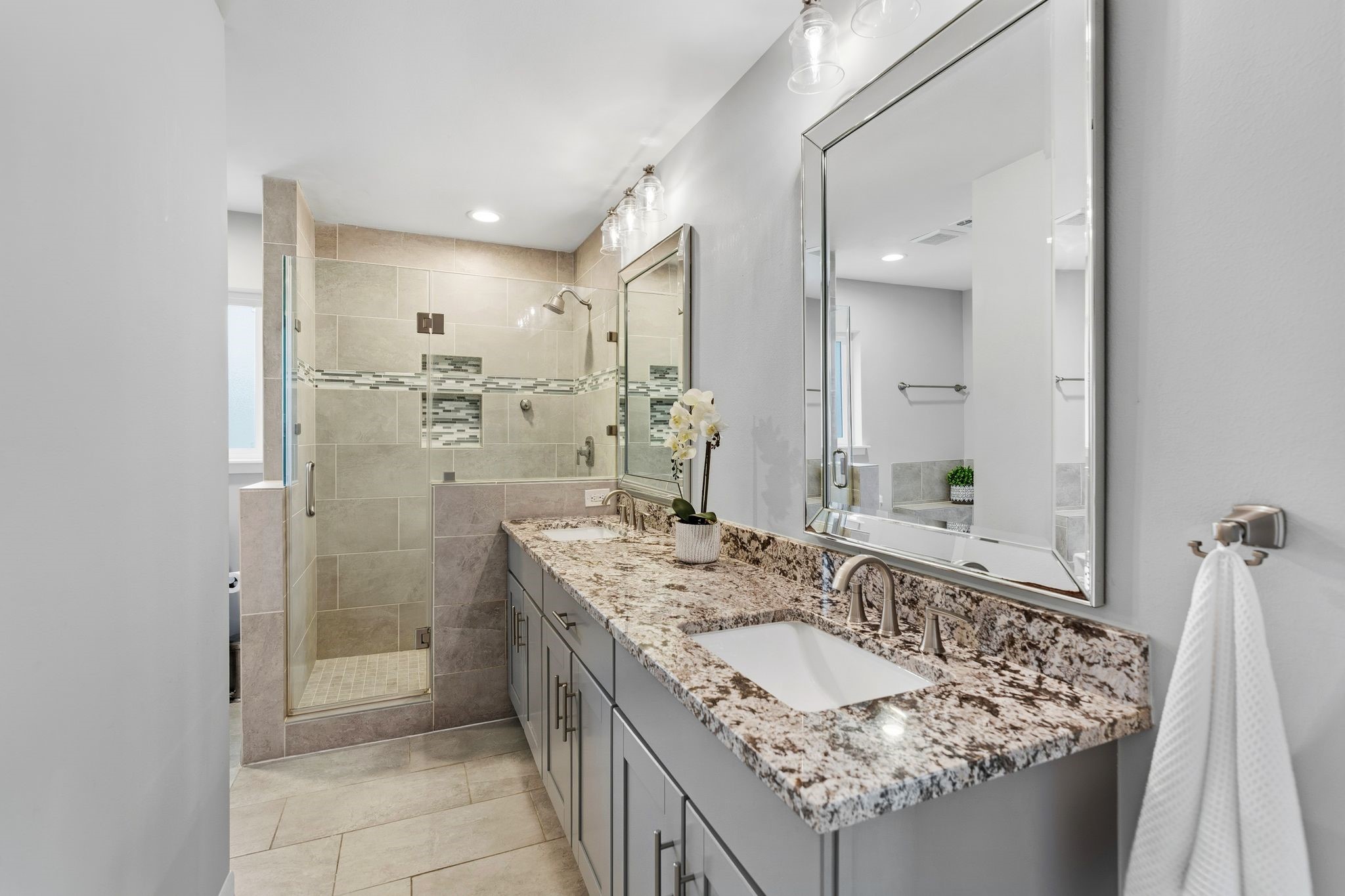 5706 Ariel Street Houston, TX 77096 - Photo 17 of 31 Primary bath offering dual sinks, a soaking tub, a separate shower, and ample built-in storage—designed for both function and comfort.