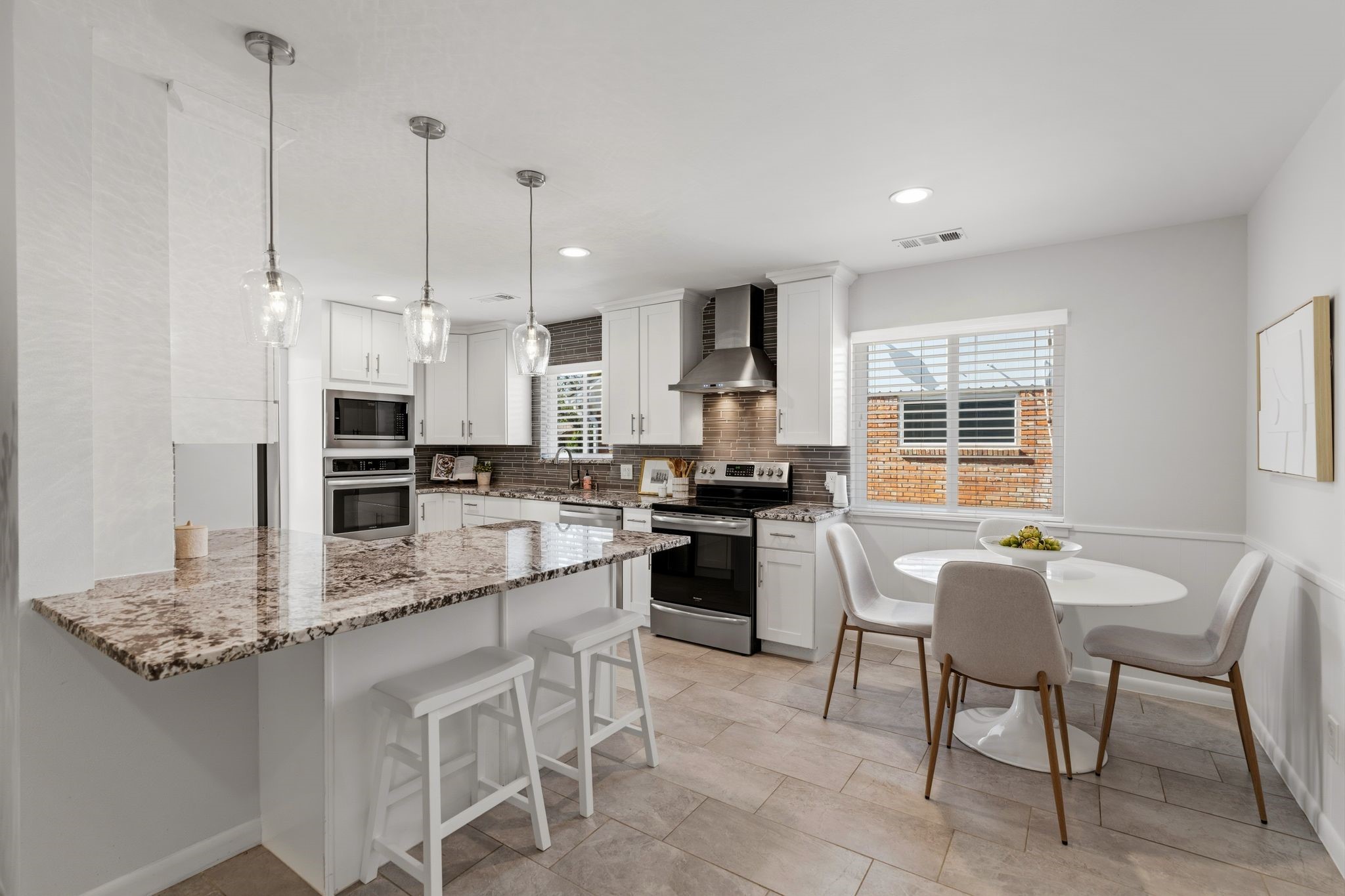 5706 Ariel Street Houston, TX 77096 - Photo 7 of 31 Well-appointed kitchen with ample storage, stainless steel appliances, breakfast nook, and an open yet subtly defined connection to the living room.