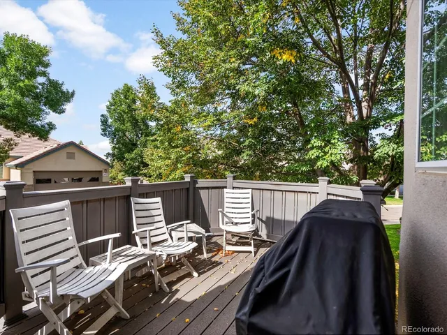 a view of roof deck with furniture and trees