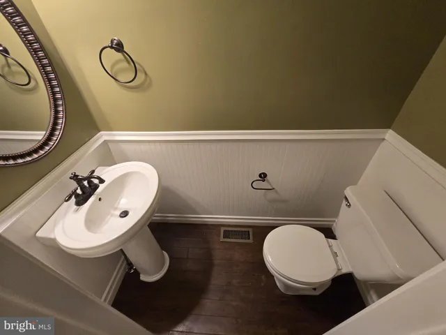 a bathroom with a toilet a sink and mirror