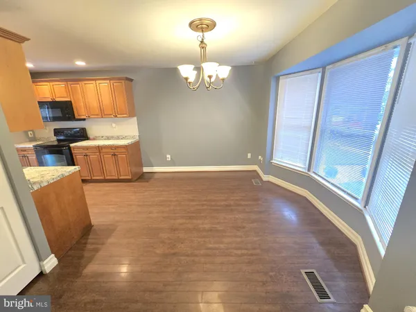 a view of a kitchen with kitchen island granite countertop wooden floor