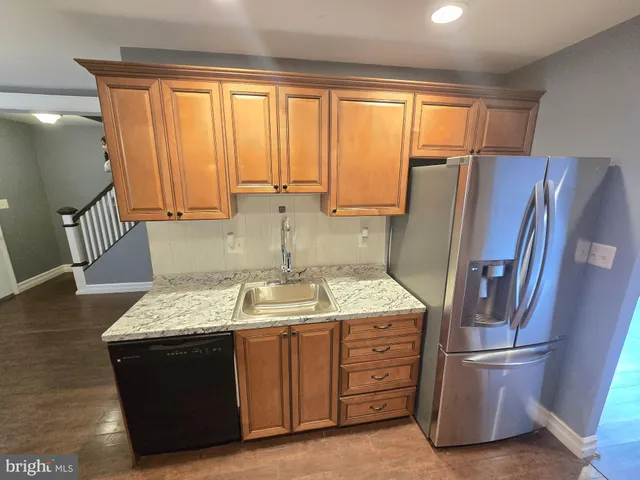 a kitchen with stainless steel appliances granite countertop a refrigerator stove and sink