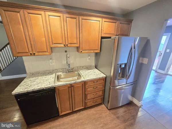 a kitchen with stainless steel appliances granite countertop a refrigerator a sink and a stove