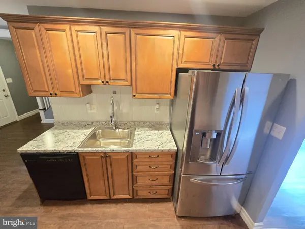 a kitchen with stainless steel appliances granite countertop a refrigerator and a sink