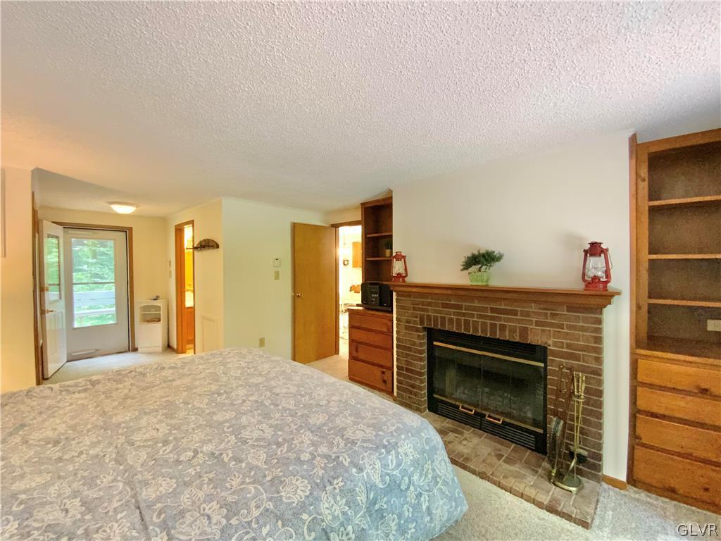 419 Merwinsburg Road Effort, PA 18330 - Photo 13 of 32 a bedroom with a bed and a fireplace