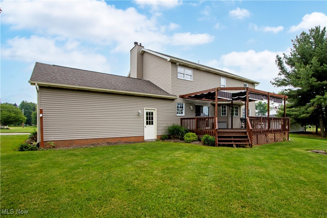 10050 Mennonite Road Rittman, OH 44270 - Photo 36 of 42 Back of property with a wooden deck, a lawn, a chimney, and a shingled roof