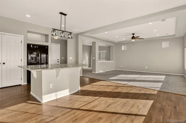 a large kitchen with kitchen island granite countertop a large window and a counter space
