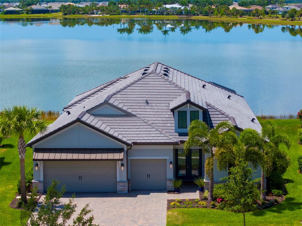 Experience ultimate luxury living with serene lake & sunset views in this exquisite maintenance free 3 bedroom + office, 3 bath Sarasota residence in the prestigious Shoreview at Lakewood Ranch Waterside