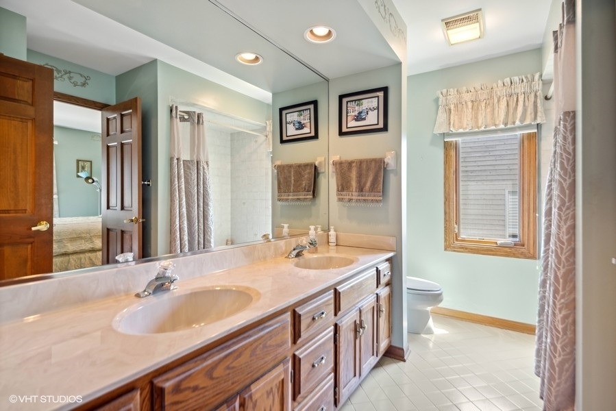 467 81st Street Burr Ridge, IL 60527 - Photo 27 of 45 a bathroom with double vanity sinks a large mirror and a shower