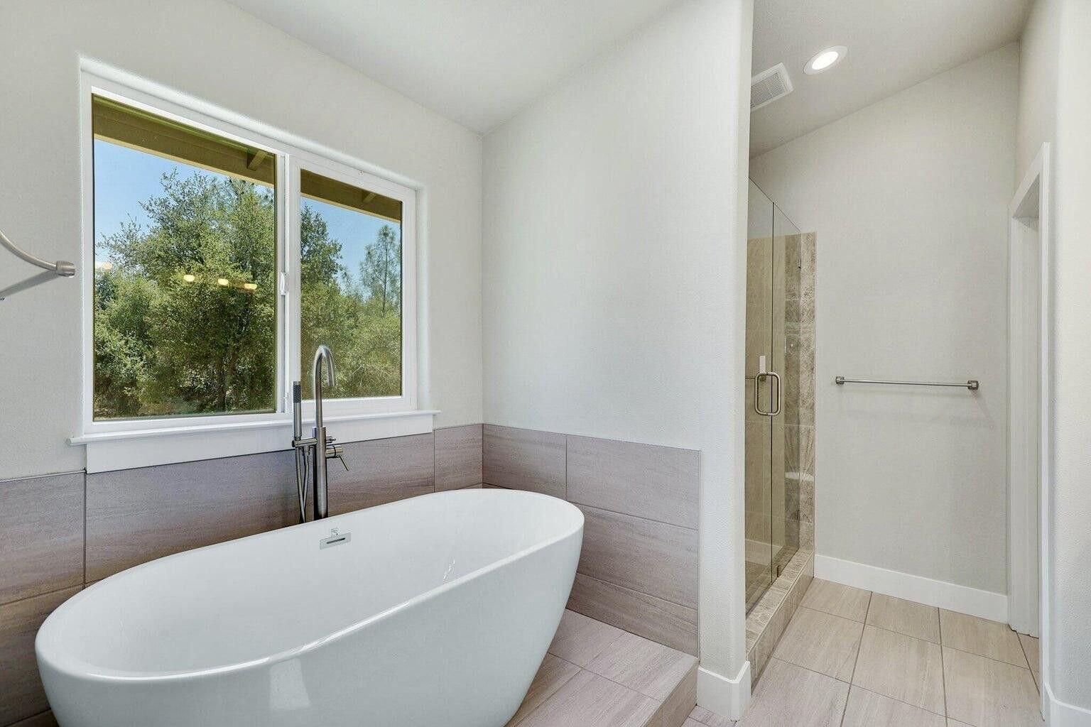 5883 Happy Valley Road Anderson, CA 96007 - Photo 8 of 30 a white bath tub sitting in a bathroom next to a window