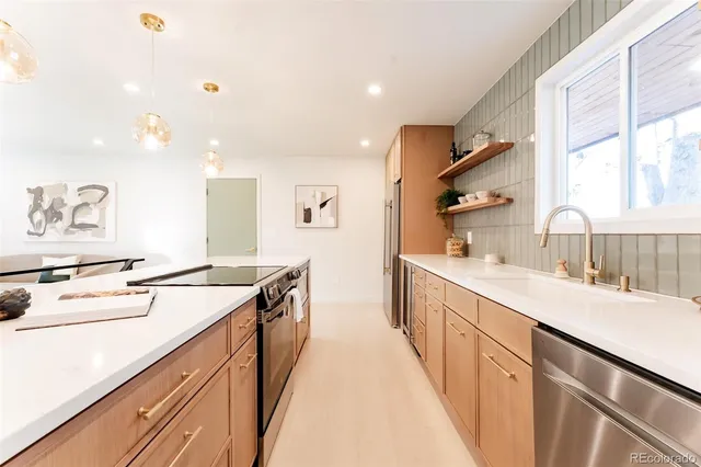 a room with kitchen island a sink and a stove with wooden floor