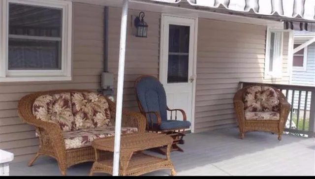 a view of a chair and table in the back yard of the house