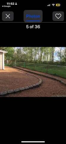 a view of a house with backyard and trees in the background