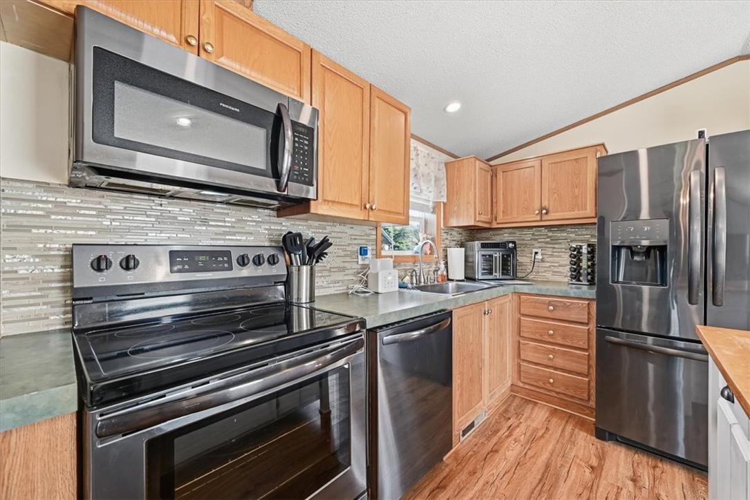 6129 Memorial Road Allentown, PA 18104 - Photo 21 of 46 Warm wood cabinetry pairs with stainless steel appliances and a mosaic tile backsplash.