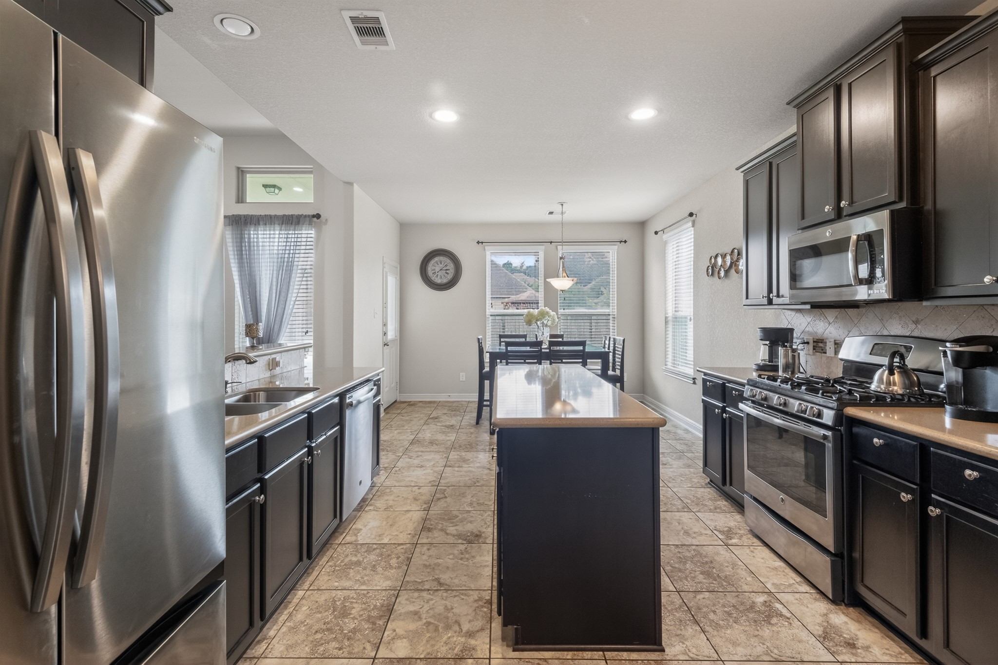 24711 East Burnaby Circle Spring, TX 77373 - Photo 9 of 20 a kitchen with stainless steel appliances granite countertop a stove top oven a sink and dishwasher