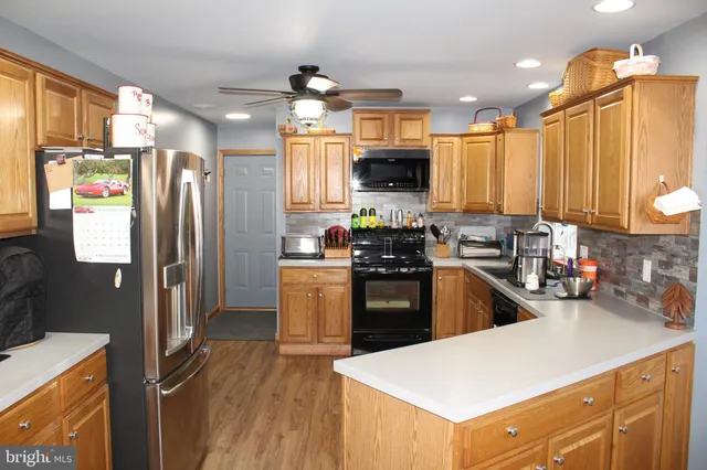a kitchen with granite countertop a sink stainless steel appliances and cabinets