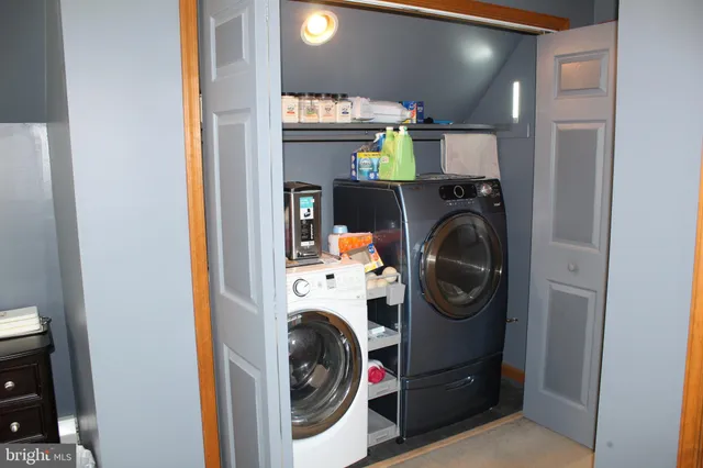 a view of a hallway to a livingroom with furniture and staircase