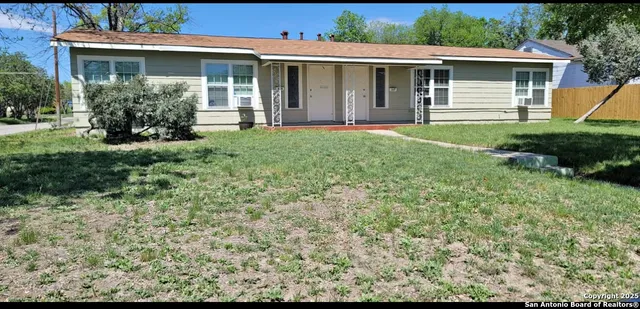 a front view of a house with a yard and potted plants