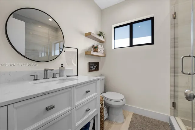 a bathroom with a toilet sink vanity and mirror