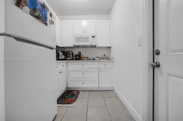 a kitchen with white cabinets and appliances