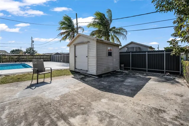 a view of a house with backyard and sitting area