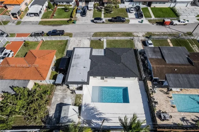 an aerial view of a houses with a swimming pool