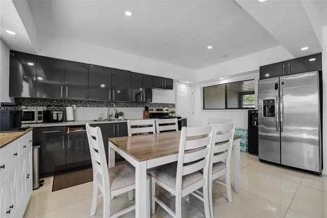 a kitchen with granite countertop a center island and stainless steel appliances