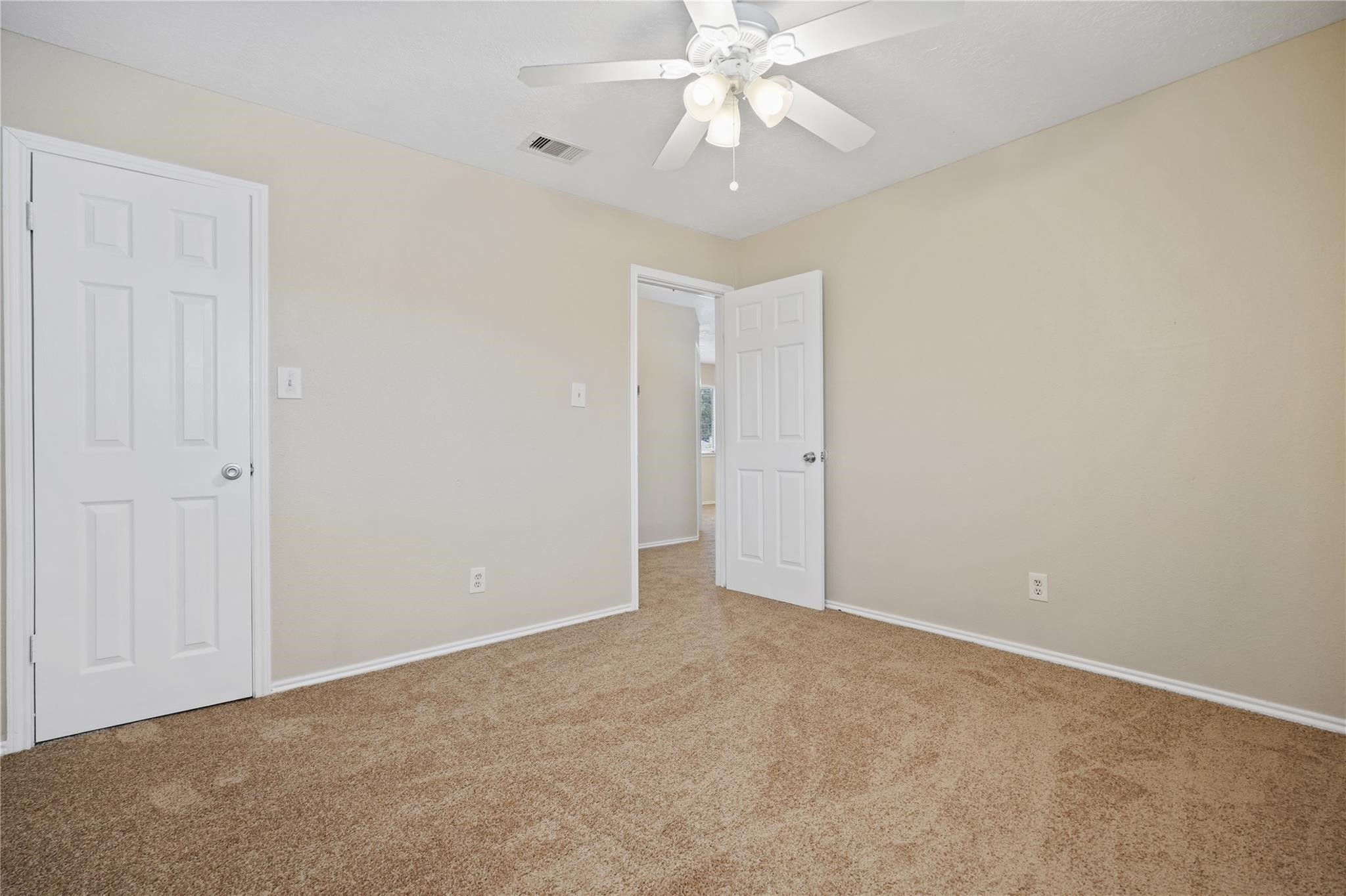 22911 Sherioaks Lane Spring, TX 77389 - Photo 23 of 26 an empty room with a chandelier fan and closet area