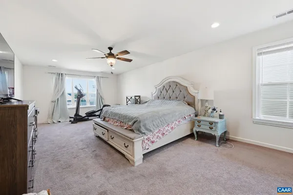 a spacious bedroom with a bed and a chandelier