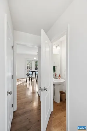 a open kitchen with granite countertop a stove a sink a dining table and chairs with wooden floor