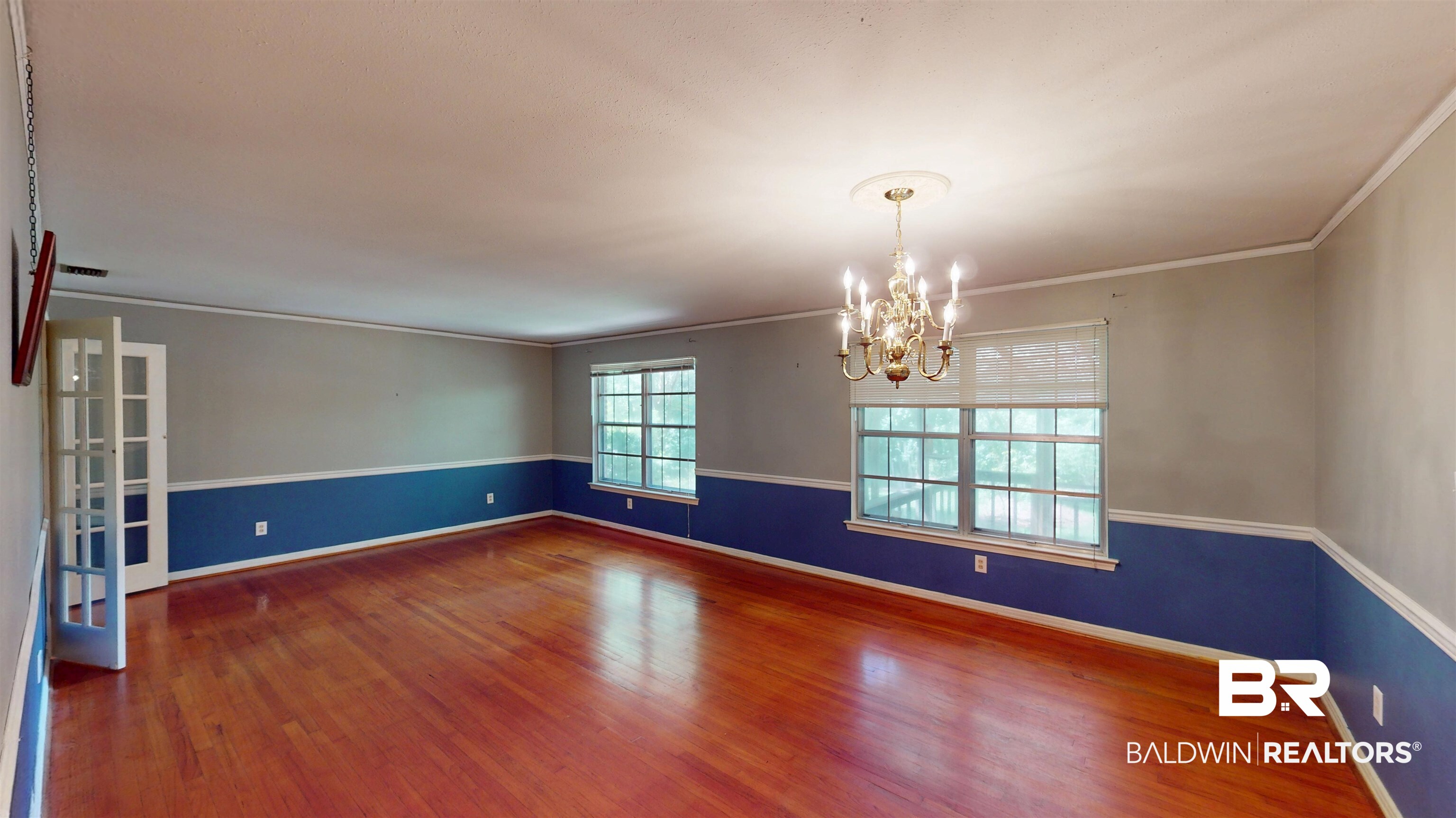 1075 Zurich Street Mobile, AL 36608 - Photo 14 of 35 Empty room with suspended lighting, dark wood-style flooring, and crown molding