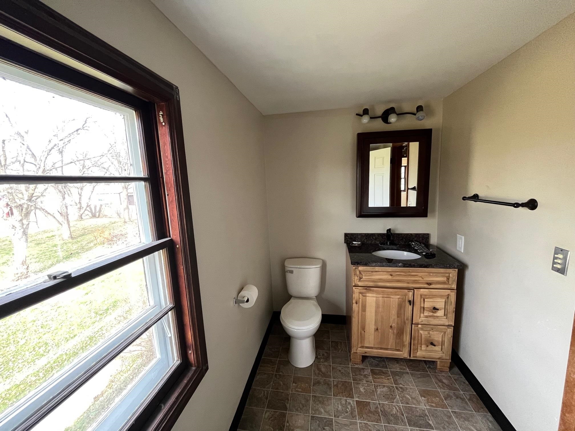 13954 Dorr Road Rockton, IL 61072 - Photo 16 of 21 a bathroom with a toilet a sink a vanity and a large window