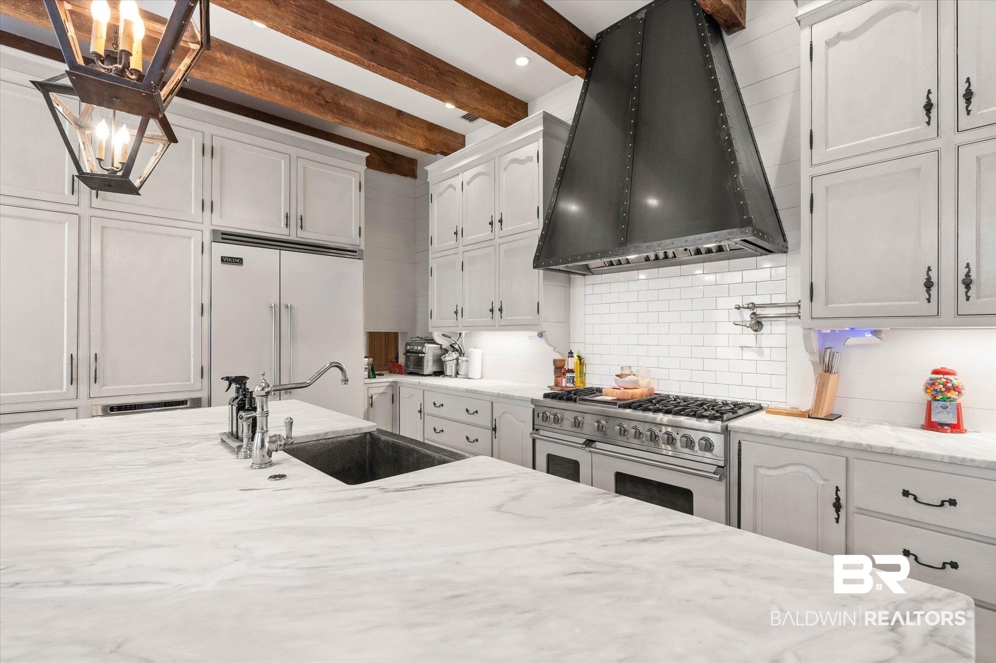 2256 De Leon Avenue Mobile, AL 36607 - Photo 14 of 61 Kitchen with white cabinets, premium appliances, light stone countertops, beam ceiling, and tasteful backsplash