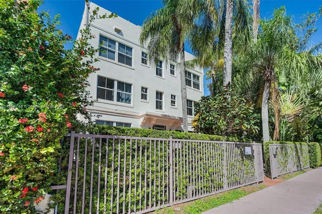 a view of a house with a small yard and wooden fence