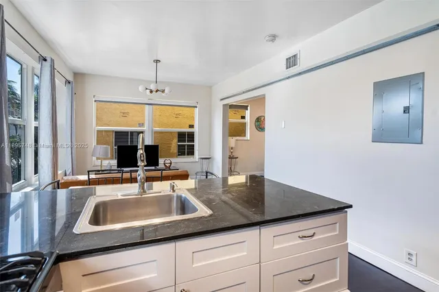 a kitchen with a sink refrigerator and chandelier
