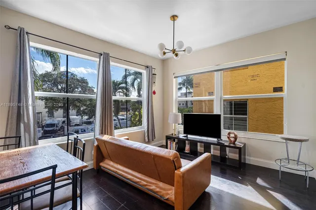 a living room with furniture tv and a window